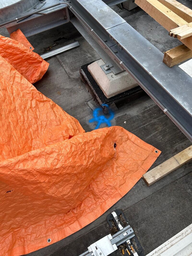 Dakdoorvoer op een plat dak afgedekt met oranje zeil