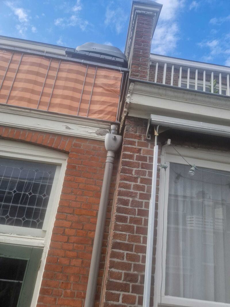 Gevel van baksteen met dakrand en balkon
