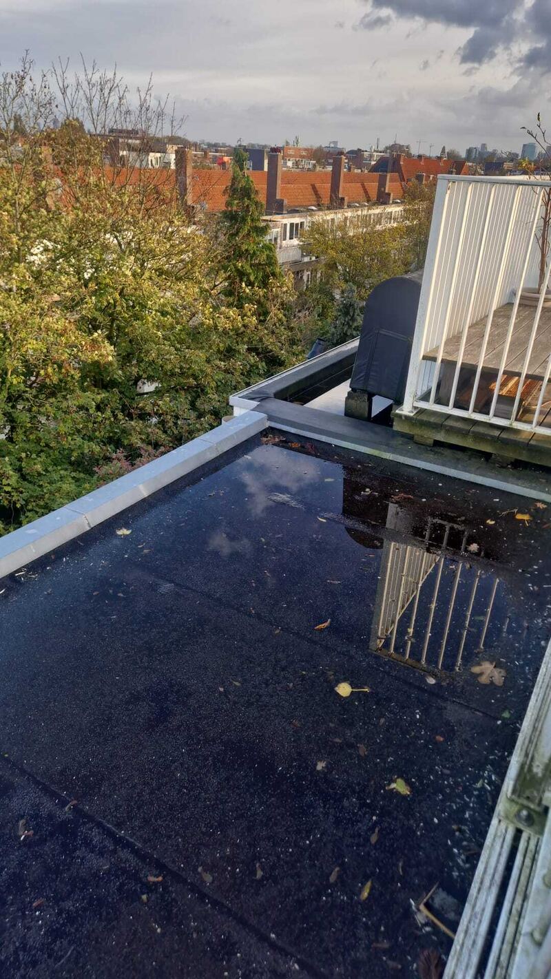 Plat dak met opstaande rand en water op de dakbedekking