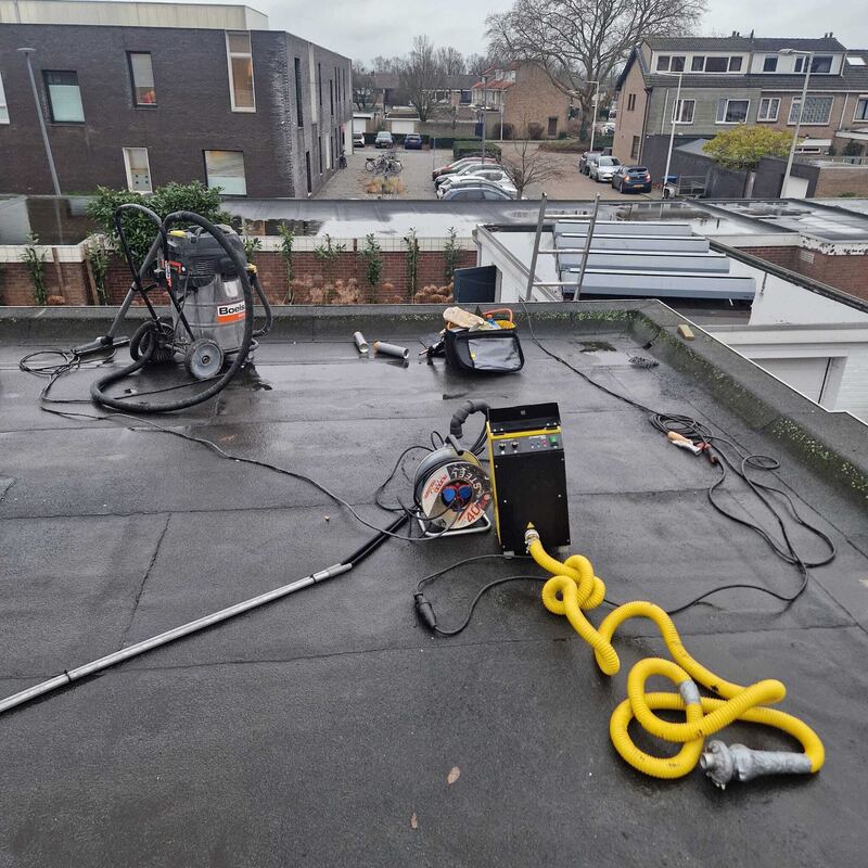 Rookmachine met slang op een plat dak
