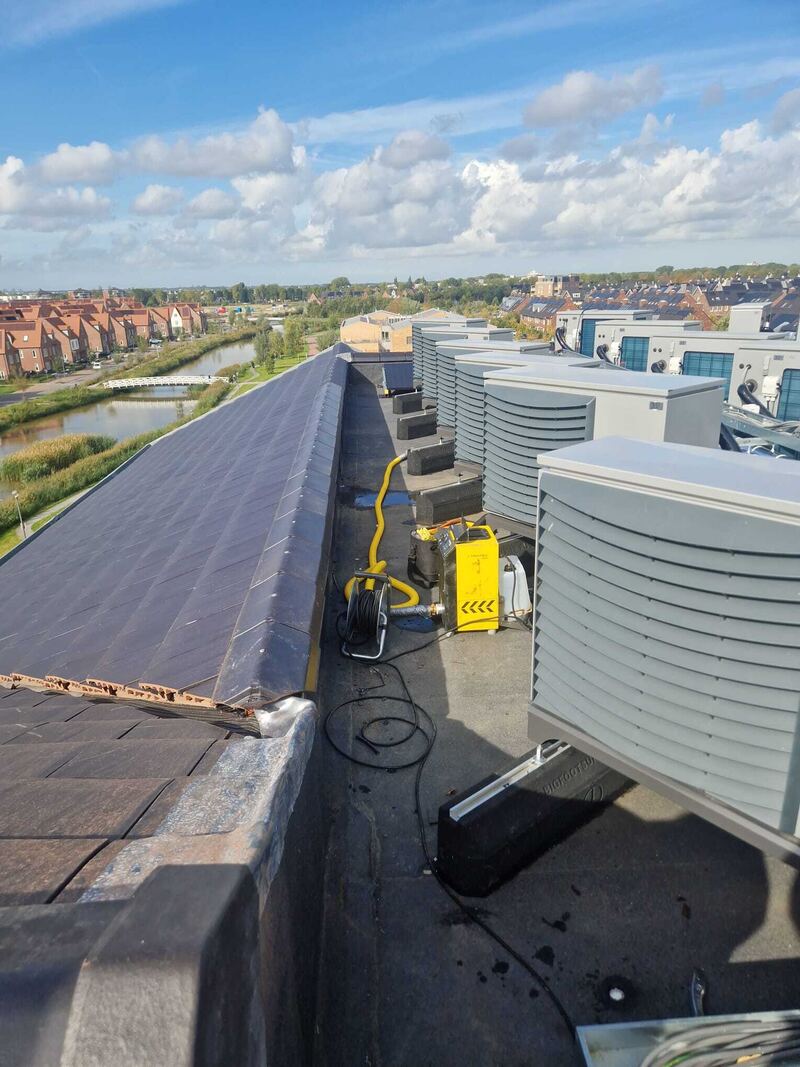 Rookmachine op een plat dak met airco-units
