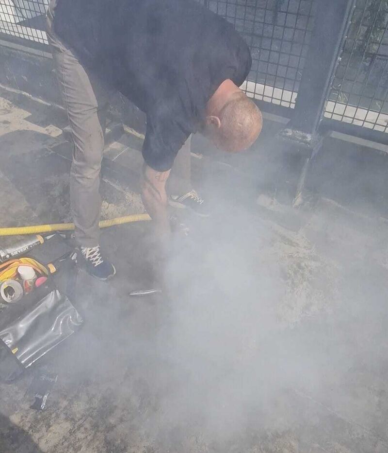 Specialist bij rook op een dakterras met hekwerk