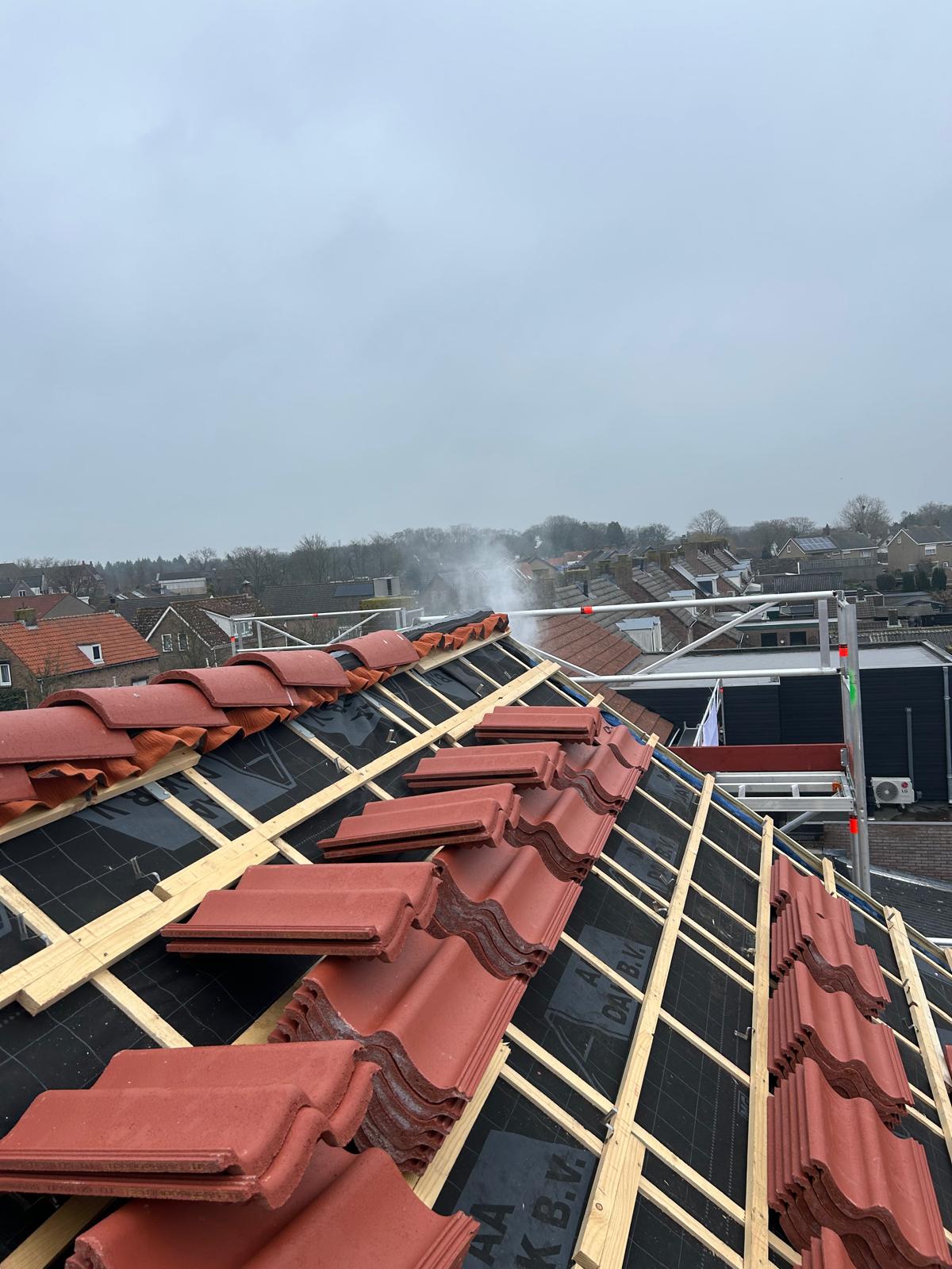 Rookgas treedt zichtbaar uit door dakconstructie bij woningcorporatieproject — rookproef lekdetectie