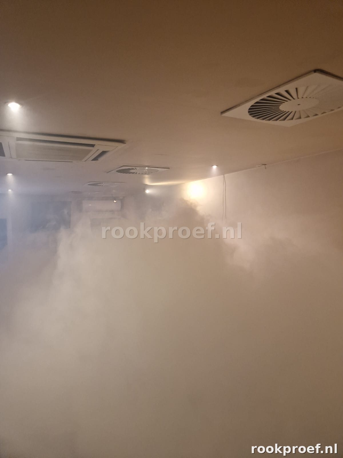 Kantoorruimte volledig gevuld met rookgas tijdens ventilatiesysteem test — plafondkanalen gecontroleerd