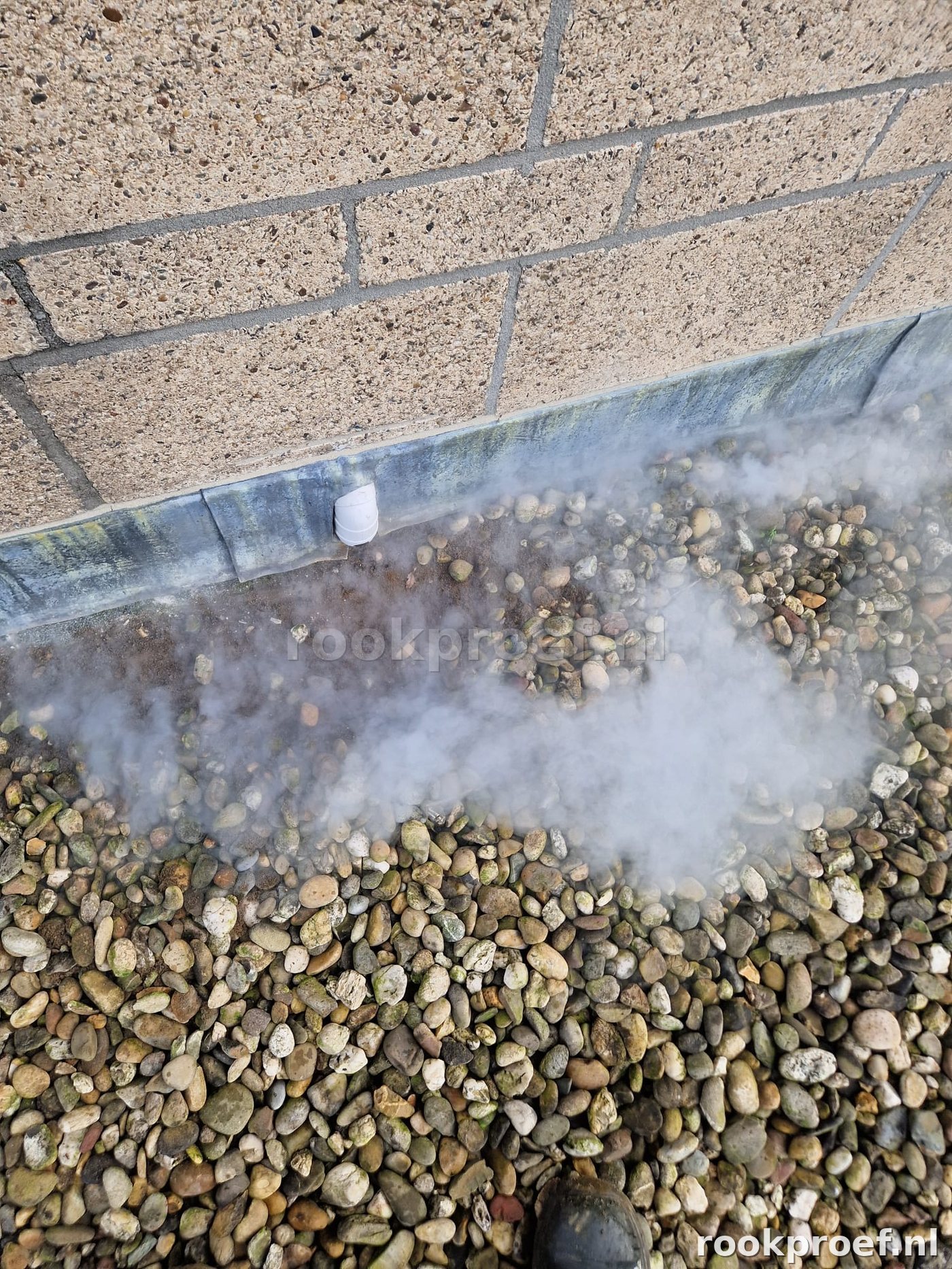 Rookproef dakrand — rook ontsnapt bij muuraansluiting op grindlaag dak
