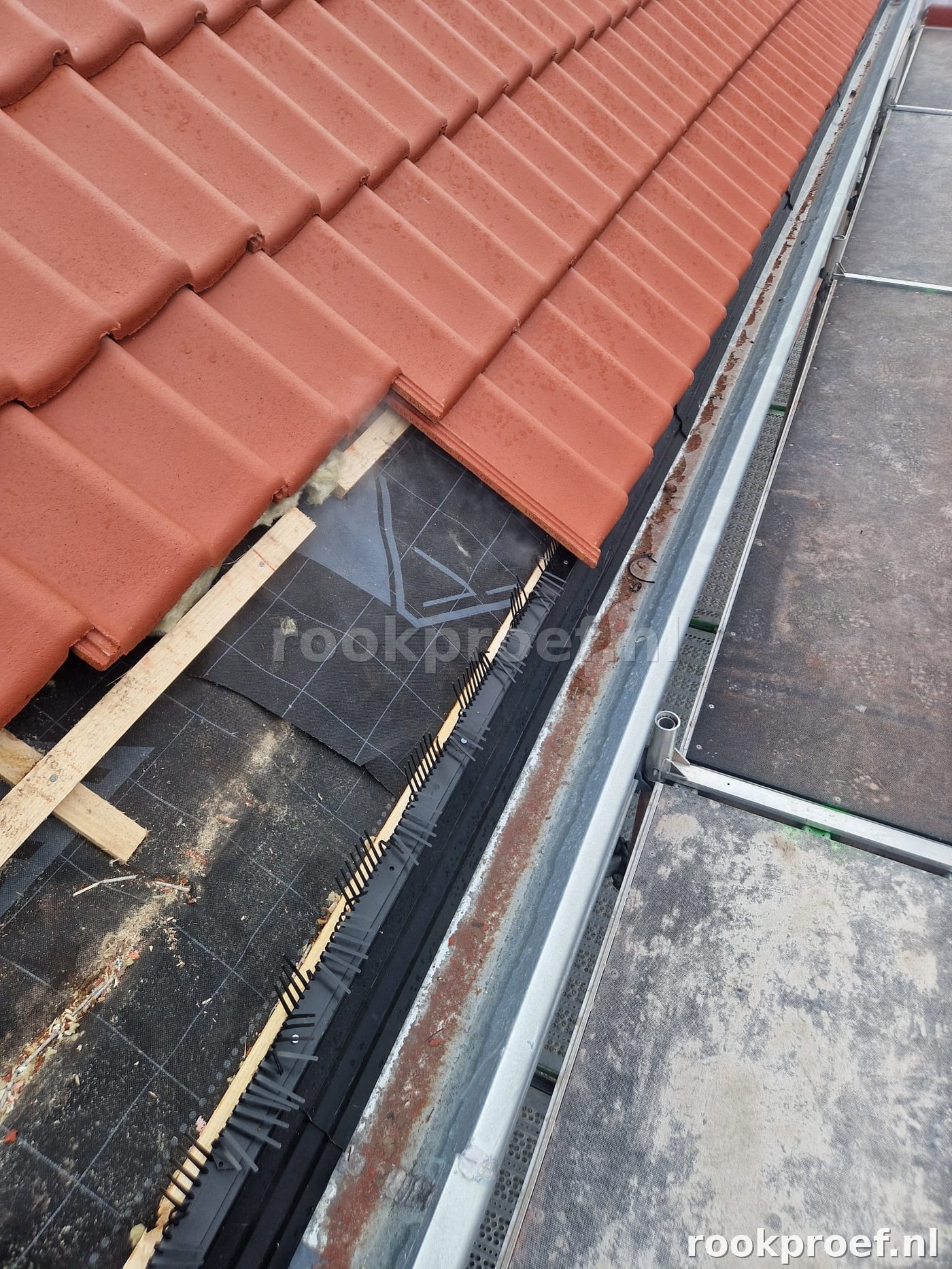 Detailopname hellend pannendak met luchtdichtheidsfolie en dakvoet — lekpunt bij nok-gootaansluiting