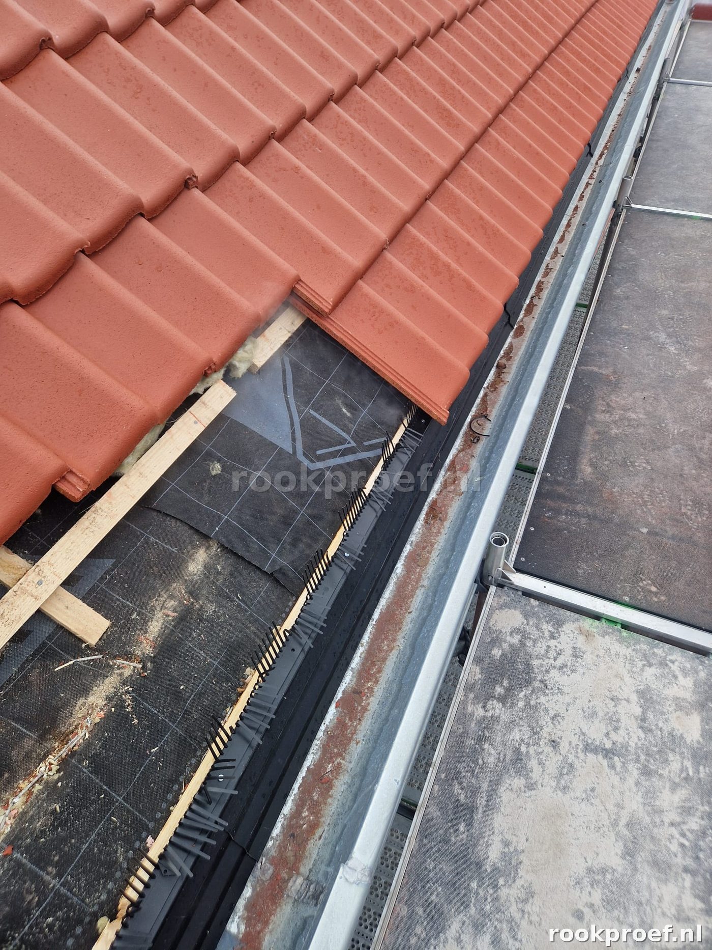 Detail dakrandaansluiting pannendak — hellend dak ontmoet plat dak rookgas lekpunten