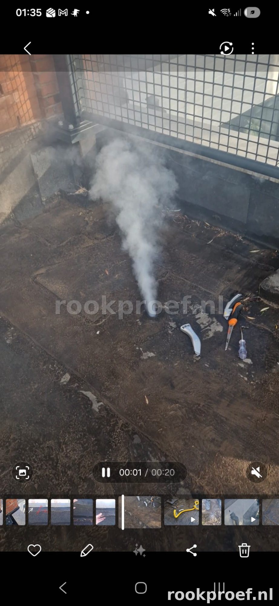 Rookproef plat dak — rookgas ontsnapt zichtbaar als fontein via lekpunt in bitumen dakbedekking