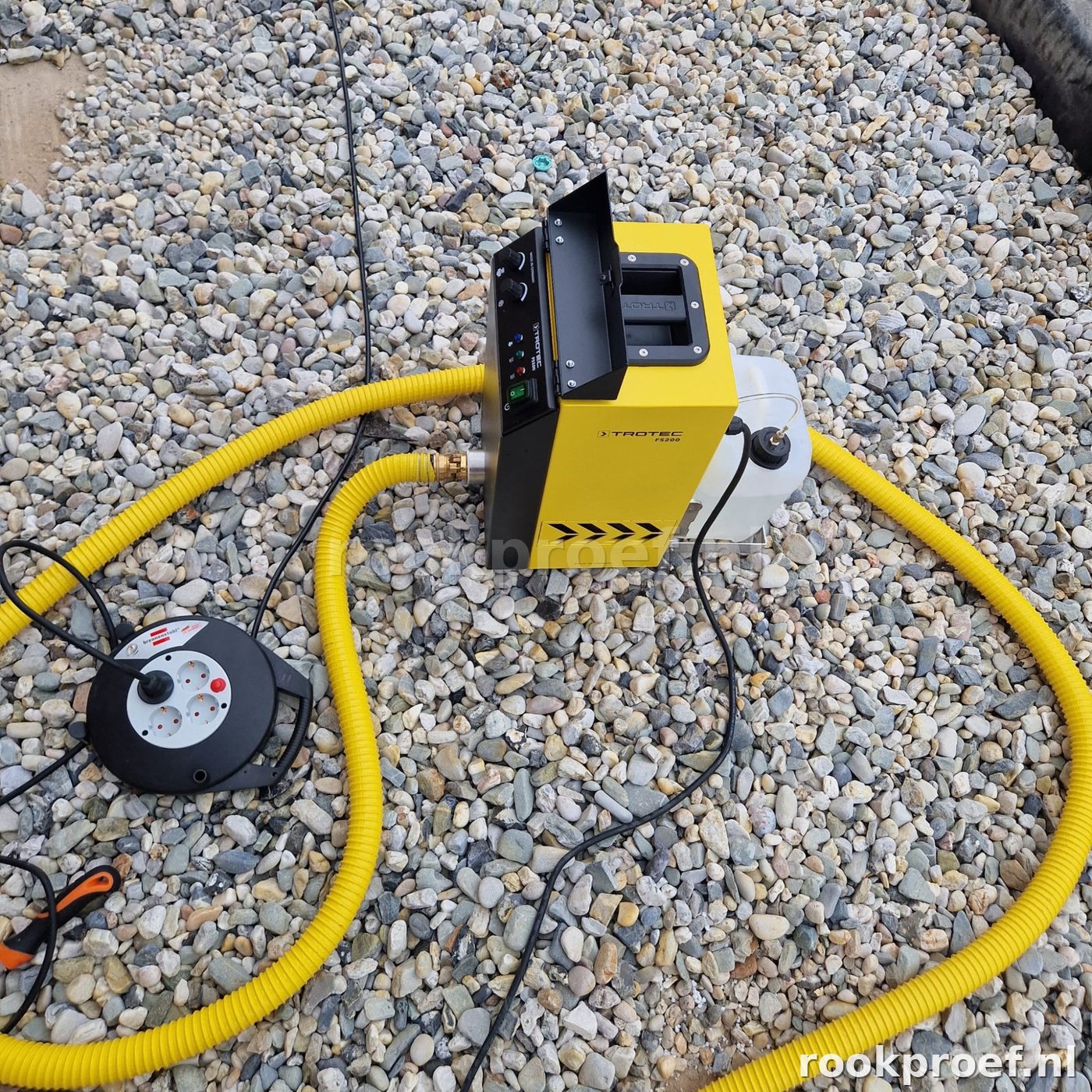 Trotec rookgenerator start rookproductie op grindlaag dak — gele slang haspel dakdoorvoer