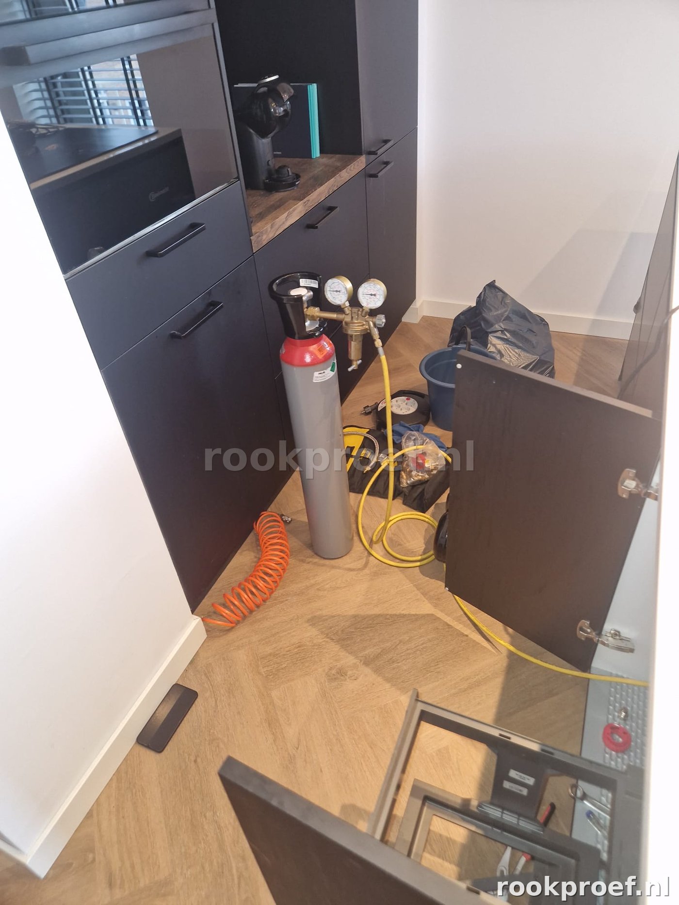 Druktest opstelling — gasfles met manometer en slangen voor drukmeting op leidingen in woning